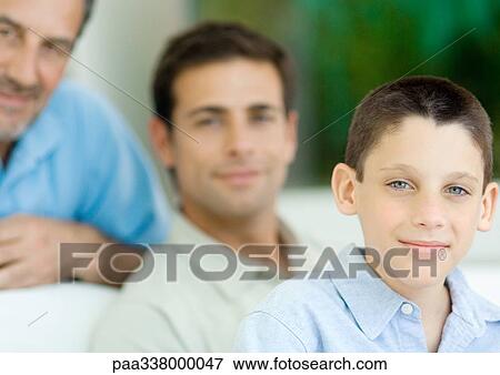Boy, portrait with father and grandfather in background View Large Photo Image Stock Photo - Boy, portrait with father and grandfather in background. Fotosearch