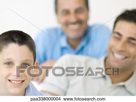 Picture - Boy with father and grandfather in background. Fotosearch