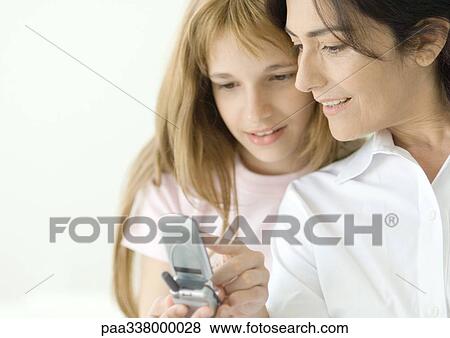 Girl looking at cell phone with mature woman View Large Photo Image Stock Photo - Girl looking at cell phone with mature woman. Fotosearch
