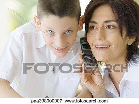 Mature woman and boy sharing cell phone View Large Photo Image Stock Photo - Mature woman and boy sharing cell phone. Fotosearch