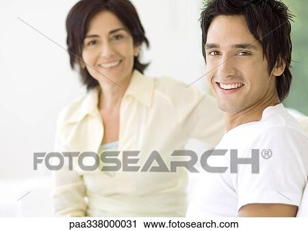 Young man with mother in background View Large Photo Image Stock Image - Young man with mother in background. Fotosearch