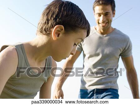 Boy captured in mid-movement, father in background View Large Photo Image Picture - Boy captured in mid-movement, father in background. Fotosearch