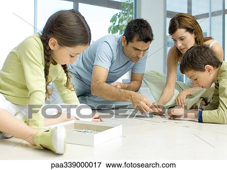 Family putting together puzzle View Large Photo Image Stock Photo - Family putting together puzzle. Fotosearch
