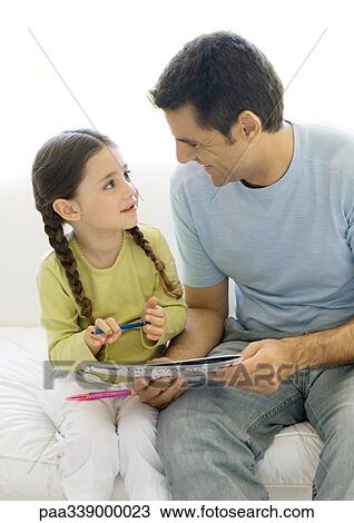 Father and daughter looking at coloring book together View Large Photo Image Stock Image - Father and daughter looking at coloring book together. Fotosearch