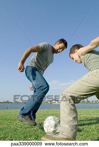 Stock Photo - Father and son playing soccer. Fotosearch