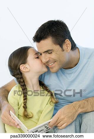 Picture - Girl kissing father's cheek while he holds book. Fotosearch