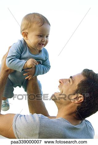 Stock Photo - Man holding up baby in air. Fotosearch