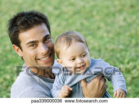 Man holding up baby View Large Photo Image Stock Photograph - Man holding up baby. Fotosearch
