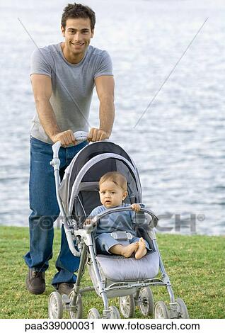 Man standing with baby in stroller View Large Photo Image Stock Image - Man standing with baby in stroller. Fotosearch