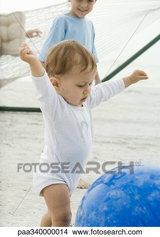 Baby reaching for ball on beach View Large Photo Image Picture - Baby reaching for ball on beach. Fotosearch