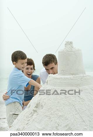 Boy showing parents sand castle View Large Photo Image Stock Image - Boy showing parents sand castle. Fotosearch