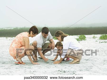 Family playing in sand together View Large Photo Image Stock Image - Family playing in sand together. Fotosearch