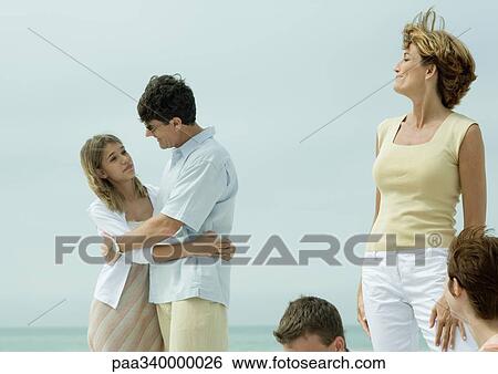 Man hugging teenage daughter while mother watches View Large Photo Image Stock Photograph - Man hugging teenage daughter while mother watches. Fotosearch