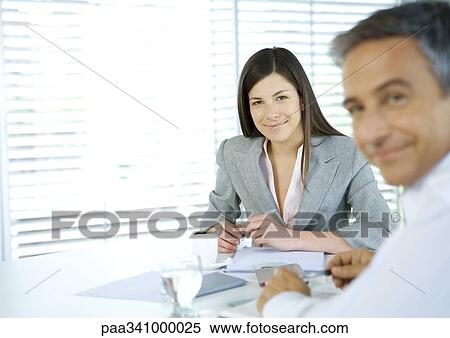 Stock Photography - Business colleagues smiling at camera. Fotosearch