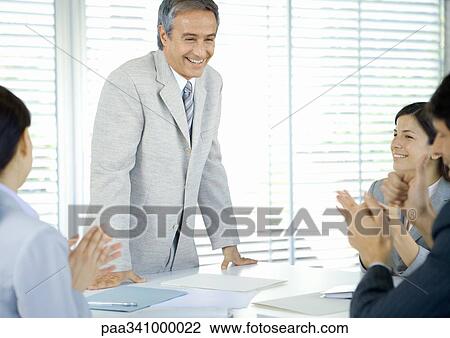 Business team applauding businessman View Large Photo Image Stock Image - Business team applauding businessman. Fotosearch