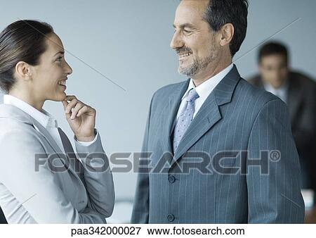 Business colleagues standing face to face, smiling View Large Photo Image Stock Photo - Business colleagues standing face to face, smiling. Fotosearch