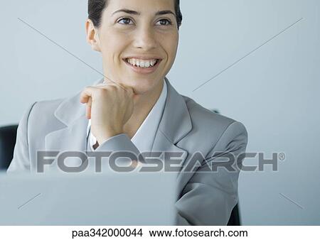 Picture - Businesswoman looking up from laptop. Fotosearch