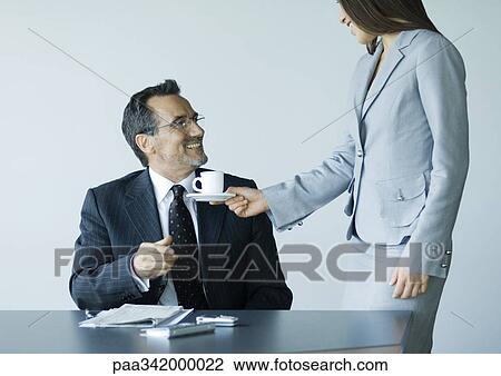 Woman handing mature businessman cup of coffee View Large Photo Image Stock Image - Woman handing mature businessman cup of coffee. Fotosearch