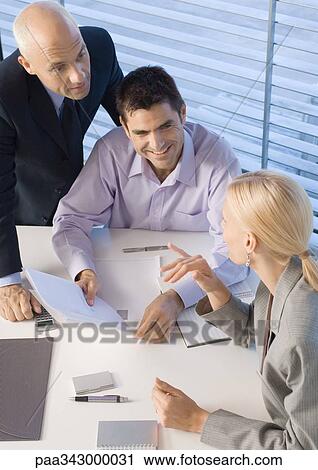 Stock Image - Business executives having discussion, high angle view. Fotosearch