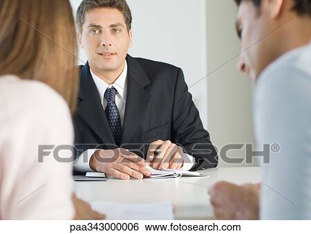 Couple having meeting with businessman View Large Photo Image Stock Photograph - Couple having meeting with businessman. Fotosearch