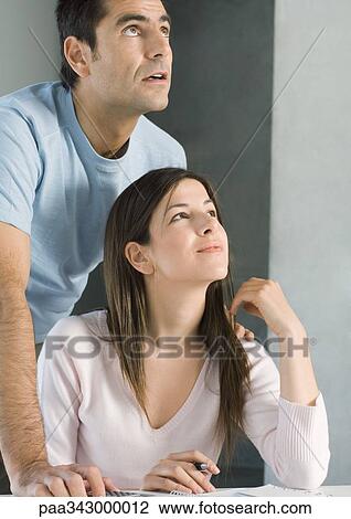 Stock Image - Couple looking up together, smiling. Fotosearch