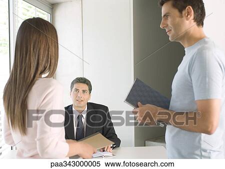 Couple speaking to businessman in office View Large Photo Image Stock Photography - Couple speaking to businessman in office. Fotosearch