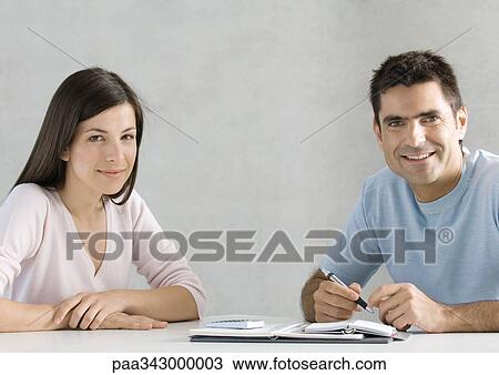 Stock Image - Couple working on budget, portrait. Fotosearch