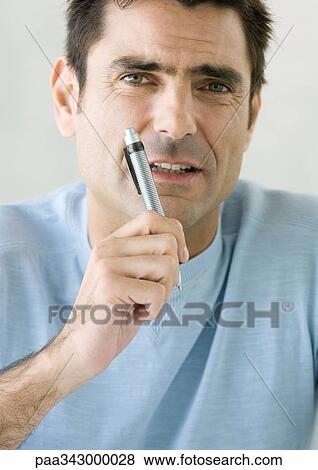 Man holding up pen and looking at camera, close-up View Large Photo Image Stock Photo - Man holding up pen and looking at camera, close-up. Fotosearch