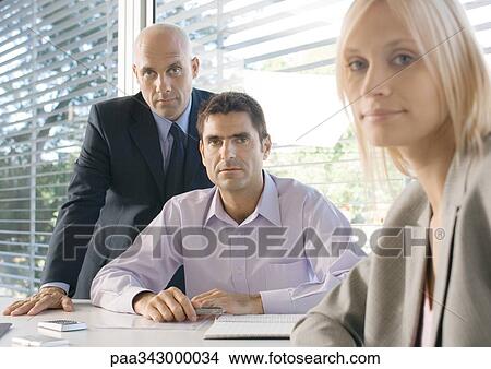 Picture - Three business executives in office, looking at camera. Fotosearch