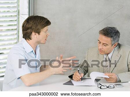 Young man speaking to mature businessman and gesturing View Large Photo Image Stock Image - Young man speaking to mature businessman and gesturing. Fotosearch