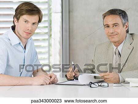 Young man with mature business man, smiling at camera View Large Photo Image Stock Image - Young man with mature business man, smiling at camera. Fotosearch