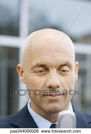 Businessman checking messages on cell phone View Large Photo Image Stock Photograph - Businessman checking messages on cell phone. Fotosearch