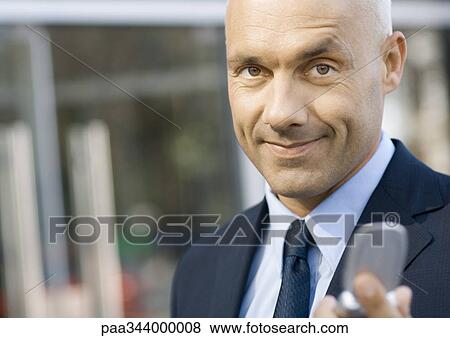 Businessman holding out cell phone View Large Photo Image Stock Photo - Businessman holding out cell phone. Fotosearch