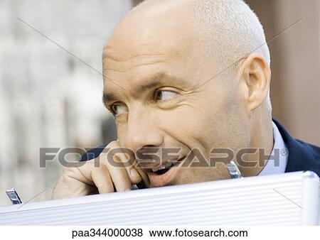 Businessman using cell phone and opening briefcase View Large Photo Image Stock Photo - Businessman using cell phone and opening briefcase. Fotosearch