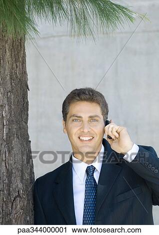 Stock Image - Businessman using cell phone. Fotosearch