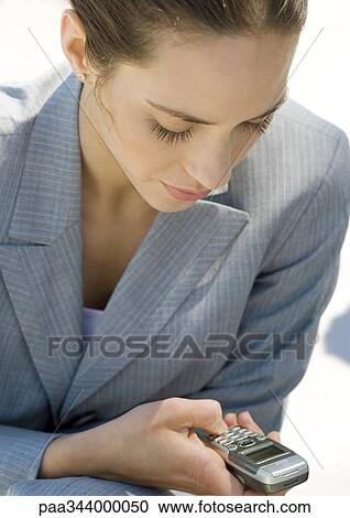 Businesswoman checking messages on cell phone View Large Photo Image Stock Image - Businesswoman checking messages on cell phone. Fotosearch
