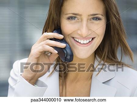 Businesswoman using cell phone, smiling View Large Photo Image Stock Image - Businesswoman using cell phone, smiling. Fotosearch