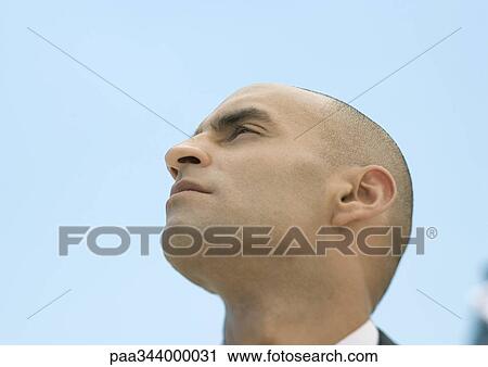 Man with shaved head, low angle view View Large Photo Image Stock Image - Man with shaved head, low angle view. Fotosearch