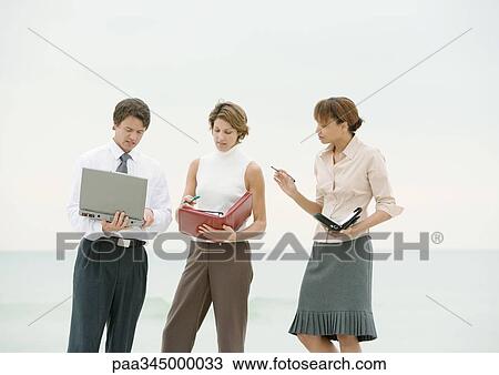 Business team consulting agendas on beach View Large Photo Image Stock Image - Business team consulting agendas on beach. Fotosearch