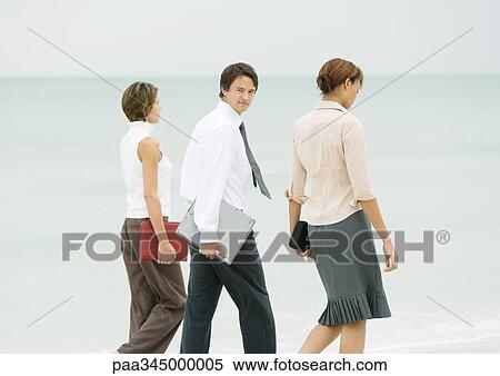 Business team walking on beach, businessman looking over shoulder at camera View Large Photo Image Stock Photography - Business team walking on beach, businessman looking over shoulder at camera. Fotosearch