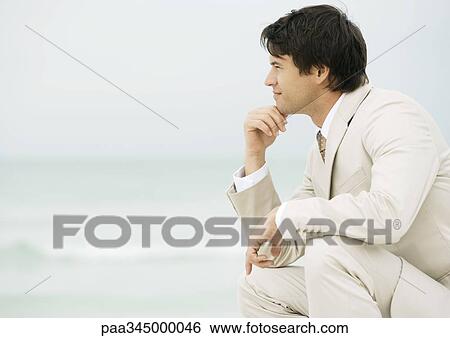 Businessman on beach, looking into the distance View Large Photo Image Stock Photograph - Businessman on beach, looking into the distance. Fotosearch