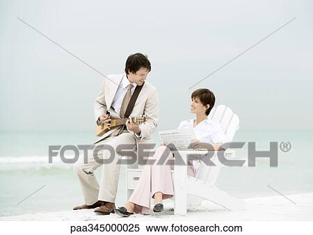 Businessman playing string instrument for woman on beach View Large Photo Image Stock Photography - Businessman playing string instrument for woman on beach. Fotosearch