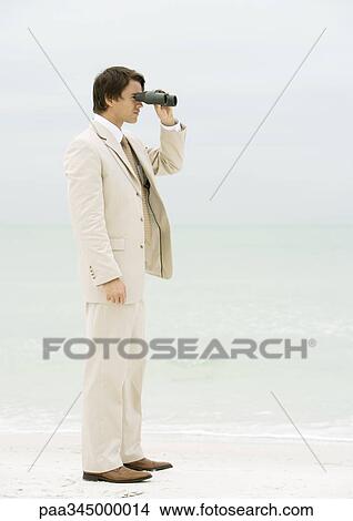 Businessman using binoculars on beach View Large Photo Image Picture - Businessman using binoculars on beach. Fotosearch