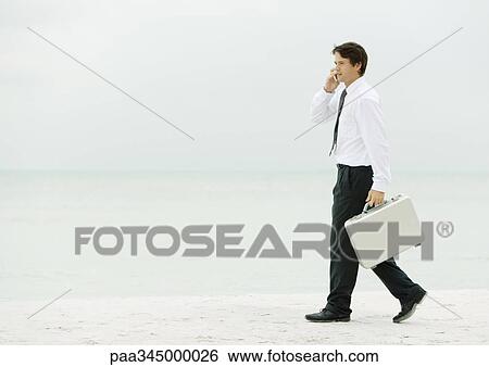 Businessman using cell phone and carrying briefcase on beach View Large Photo Image Stock Photograph - Businessman using cell phone and carrying briefcase on beach. Fotosearch
