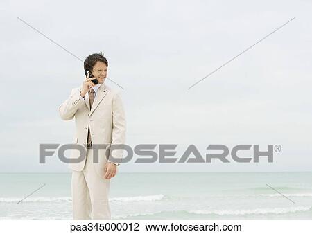 Businessman using cell phone on beach View Large Photo Image Stock Image - Businessman using cell phone on beach. Fotosearch