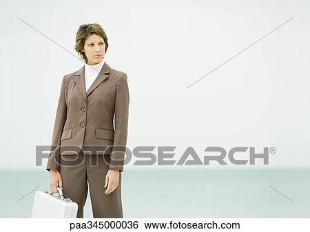 Businesswoman standing on beach View Large Photo Image Stock Photograph - Businesswoman standing on beach. Fotosearch