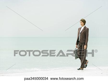 Businesswoman walking on beach View Large Photo Image Picture - Businesswoman walking on beach. Fotosearch