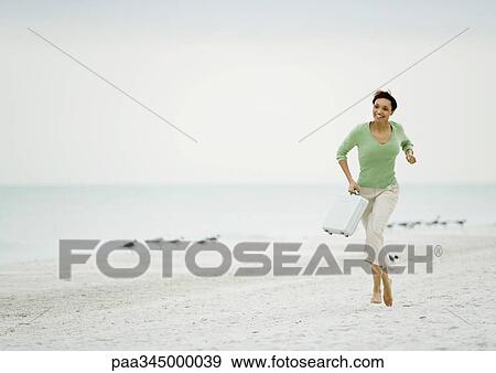 Woman running on beach with briefcase View Large Photo Image Stock Photo - Woman running on beach with briefcase. Fotosearch
