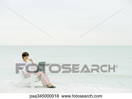 Woman using laptop on beach View Large Photo Image Stock Photo - Woman using laptop on beach. Fotosearch