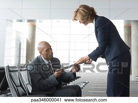 Airline attendant handing seated businessman a ticket View Large Photo Image Stock Image - Airline attendant handing seated businessman a ticket. Fotosearch